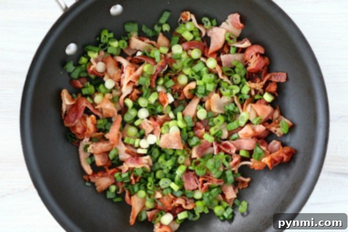 A vibrant breakfast casserole with eggs, bacon, cheese, and potatoes, garnished with fresh chives.