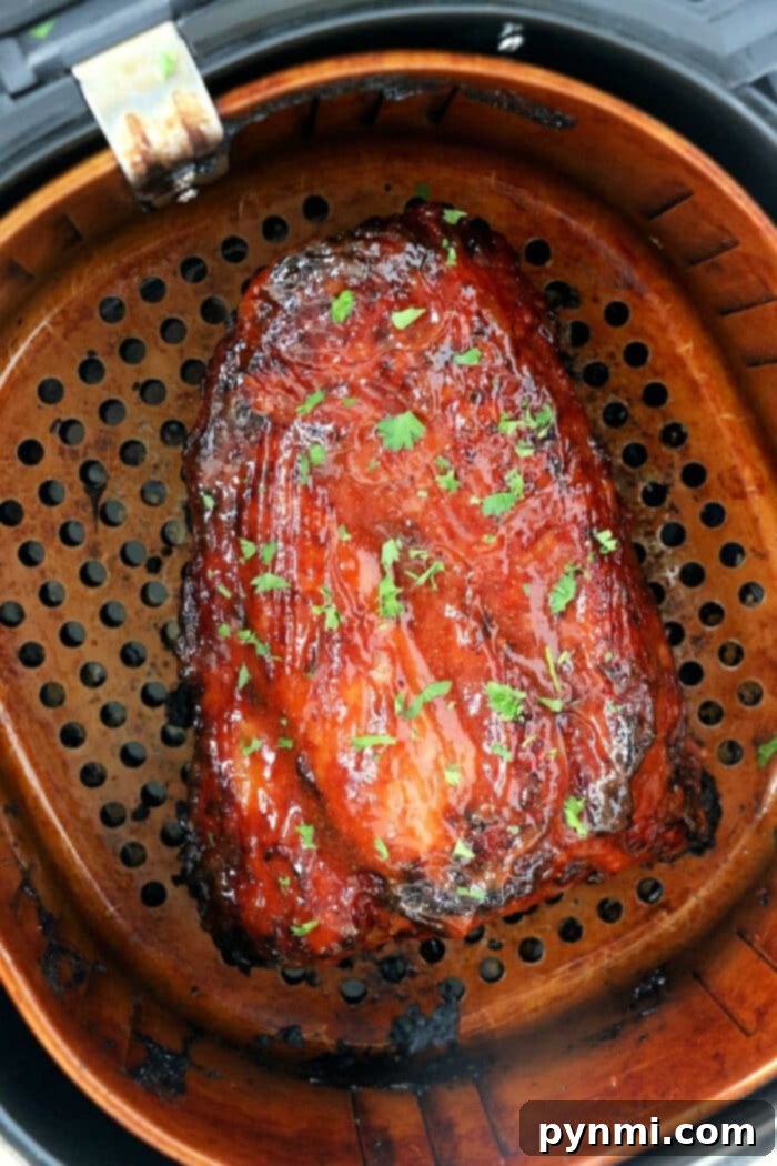 Air Fried Pork Rib Perfection 2 Succulent BBQ air fryer ribs garnished with fresh herbs on a wooden cutting board.