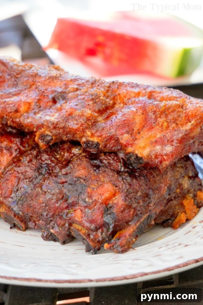 Air Fried Pork Rib Perfection 6 A beautifully smoked rack of ribs rests on a grill, showcasing a rich, dark crust and tantalizing aroma, ready to be sliced and served.