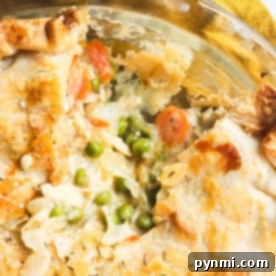 A close-up of a leftover turkey pot pie with a flaky crust reveals carrots, peas, and a rich filling without cream of chicken.