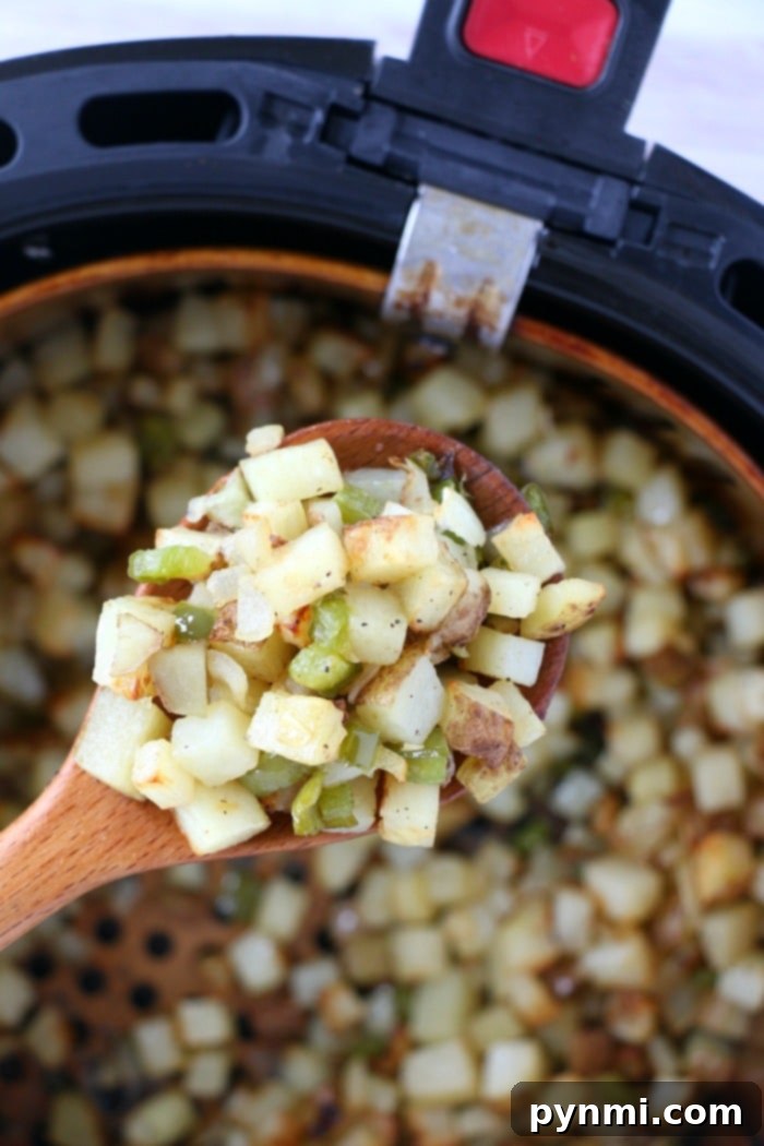 Air fryer breakfast potatoes with bell peppers topped with cheese are great with eggs, or make breakfast for dinner some night! Cheap and full of flavor. A close-up of perfectly diced potatoes, seasoned and ready for air frying to become delicious breakfast potatoes.