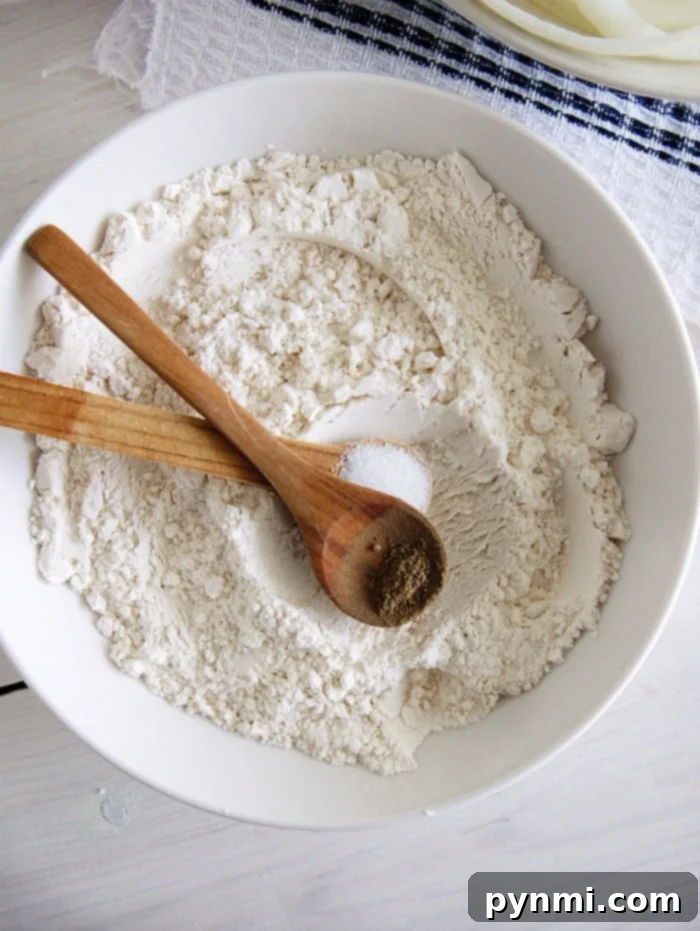 Your Guide to Flour Swaps 4 Close-up of flour being measured into a cup, highlighting the texture and purity of baking ingredients.