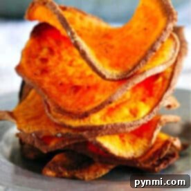 A stack of crispy, homemade sweet potato chips air fryer-style sits on a plate, perfectly golden and delicious.