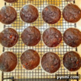 Chocolate banana muffins cooling on a wire rack, arranged in rows.