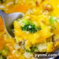 Close-up of a cheesy Instant Pot chicken broccoli and rice casserole being scooped with a spoon.