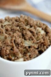 Effortless Crockpot Ground Beef Meals 8 Cooked crockpot ground beef mixed with chopped onions in a bowl.