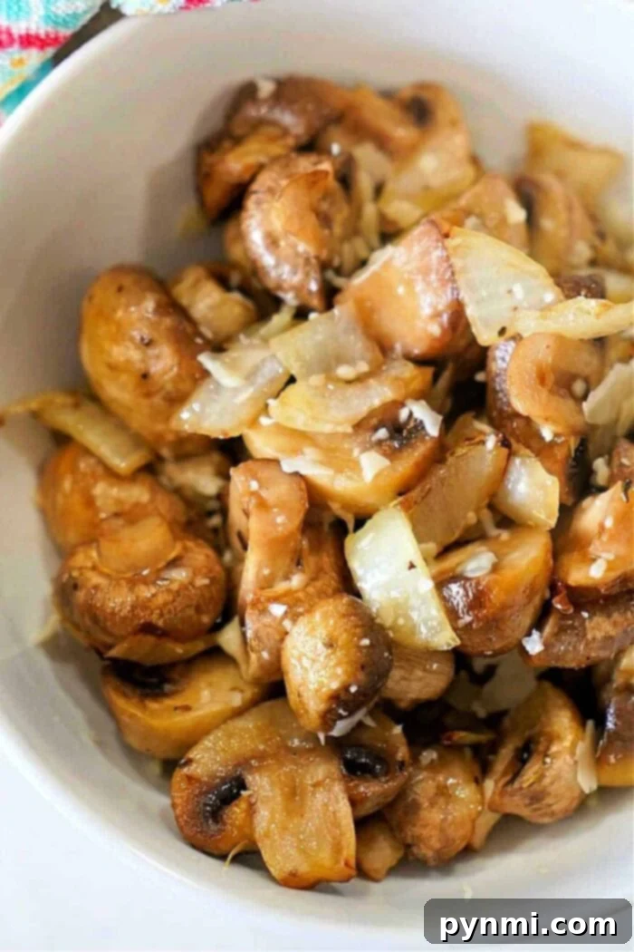 Air Fryer Mushrooms and Onions, golden brown and perfectly cooked, in a Ninja Foodi basket.