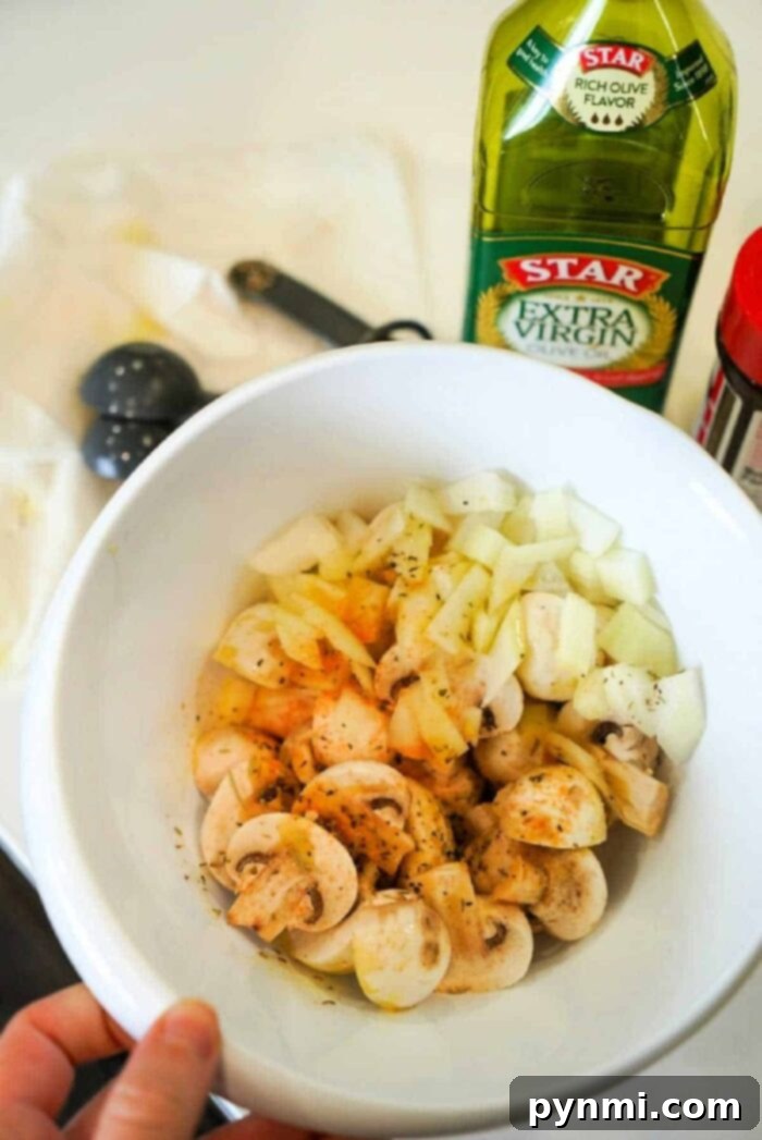 A serving of air fryer mushrooms and onions in a bowl.