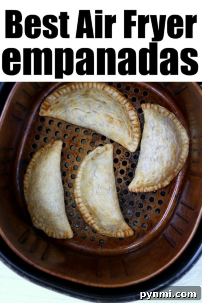 Golden Crispy Air Fryer Empanadas 8 Four golden empanadas rest in an air fryer basket, with the words Best Air Fryer Empanadas proudly displayed above, highlighting their perfect crispness.