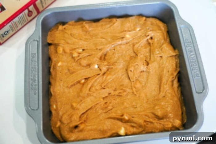 Baking pan filled with unbaked pumpkin blondies batter, ready to go into the oven.