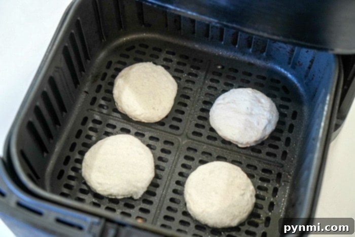 Perfect Air Fryer Frozen Biscuits 6 Perfectly golden-brown air fryer frozen biscuits arranged neatly in a basket.