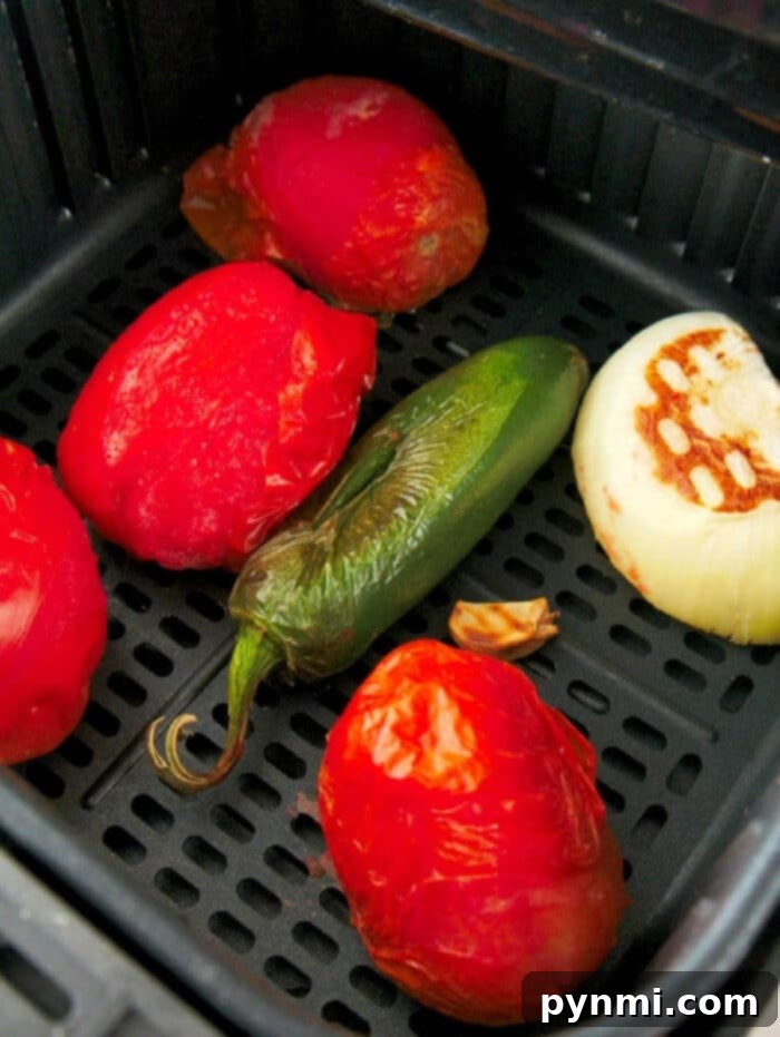 Flavor-Packed Air Fryer Tomatoes 2 Beautifully roasted tomatoes ready for homemade salsa or pasta sauce, demonstrating the perfect doneness from the air fryer.