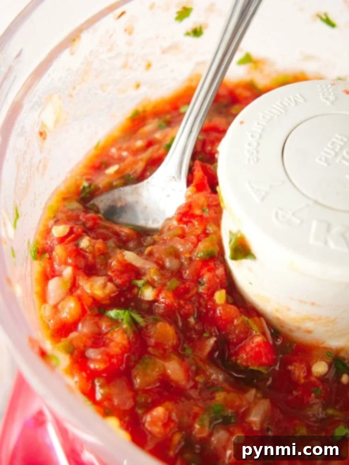 Flavor-Packed Air Fryer Tomatoes 10 A close-up shot of a vibrant homemade salsa in a bowl, with roasted tomato chunks and fresh cilantro visible.