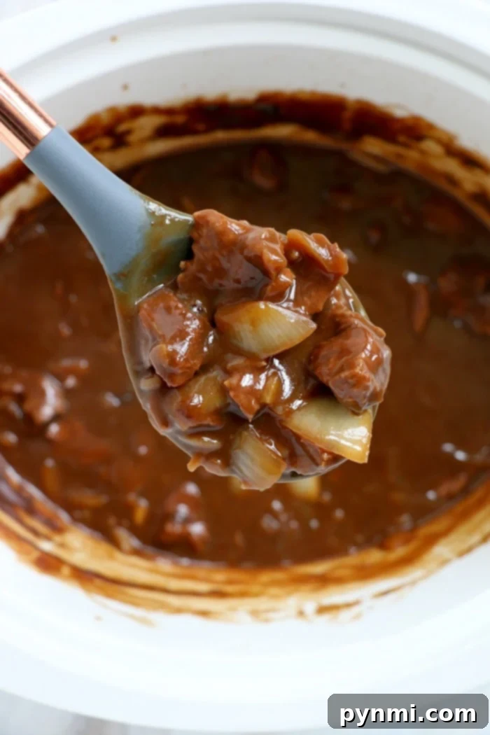 Slow Cooker Beef Tips and Gravy served with creamy mashed potatoes in a white bowl