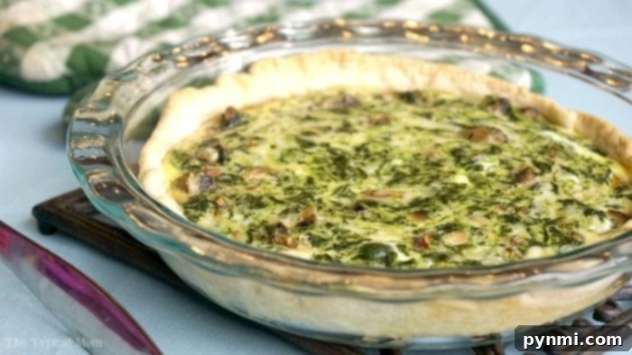 A slice of homemade spinach quiche on a white plate, ready to be enjoyed