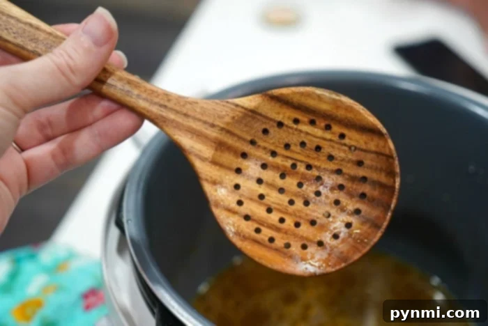 Easy Instant Pot Mushrooms 7 A wooden slotted spoon, ideal for serving Instant Pot dishes