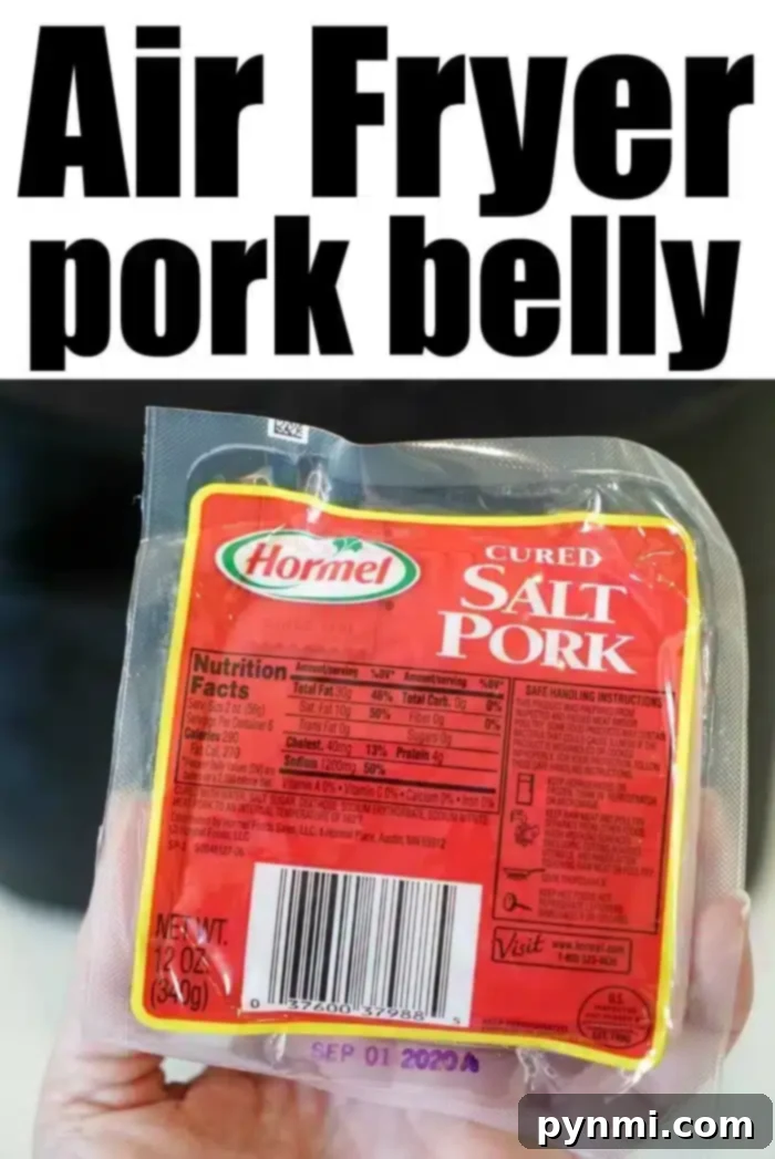 A hand holds a pack of Hormel cured salt pork, perfect for making air fryer pork belly. The packaging displays nutritional facts and a barcode. The text above the image reads "Air Fryer pork belly" in bold black letters. The expiration date on the package is September 01, 2023.