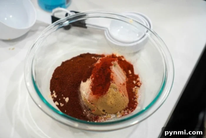 Easy Instant Pot Frozen Pork Chops 7 A glass bowl filled with spices and brown sugar, perfect for crafting the ideal smoked pulled pork on your Traeger grill, sits at the center, surrounded by measuring cups.