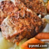 Pan-seared pork chops, starting from frozen, are perfectly cooked in an Instant Pot with spices and served alongside roasted carrots and cabbage on a plate.