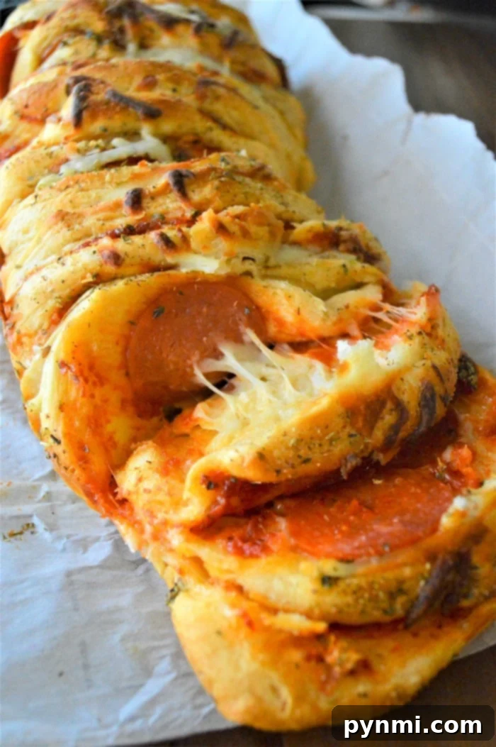 Ultimate Pizza Monkey Bread 5 Freshly baked pizza pull apart bread with melted cheese and pepperoni, presented in a rustic setting