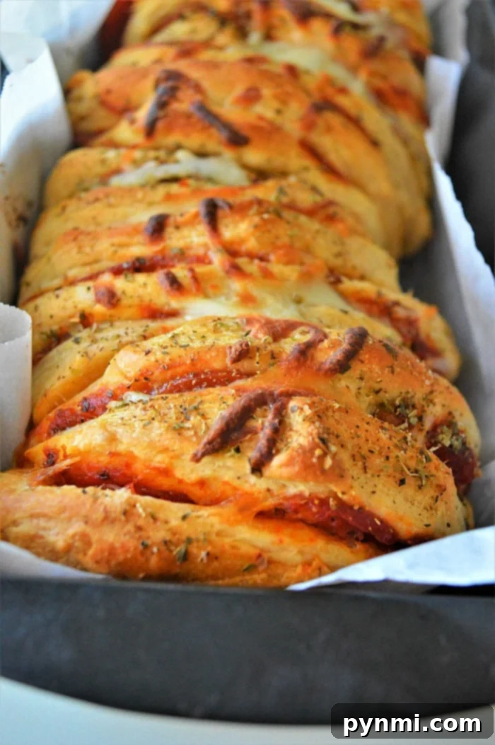 Ultimate Pizza Monkey Bread 8 Serving platter with multiple pieces of pull apart pizza bread and a side of marinara dipping sauce