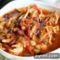 A bowl of white bean chicken chili with beans and vegetables sits invitingly on a tablecloth, effortlessly prepared in an Instant Pot.