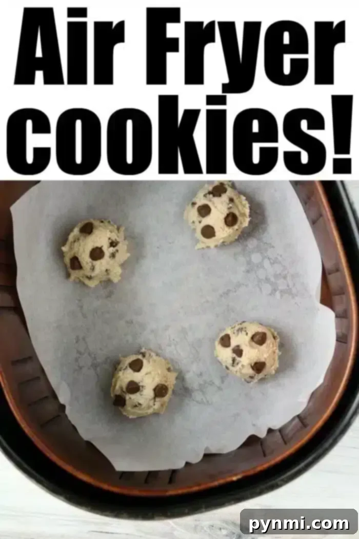 Air Fried Chocolate Chip Perfection 5 Four perfectly portioned chocolate chip cookie dough balls rest on parchment paper inside an air fryer basket, poised for baking into a delicious treat.