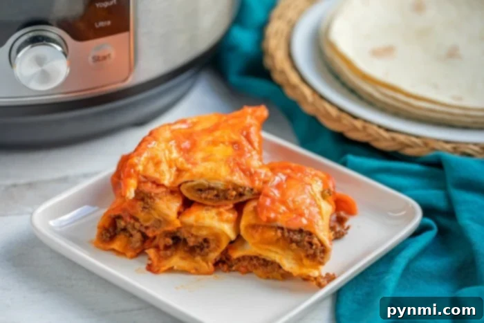 Homemade beef enchiladas served with a side of fresh toppings and a vibrant Mexican spread.