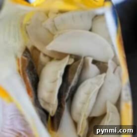 Open bag of frozen dumplings viewed from above, showing several uncooked, crescent-shaped pieces inside—perfect for making potstickers in air fryer.