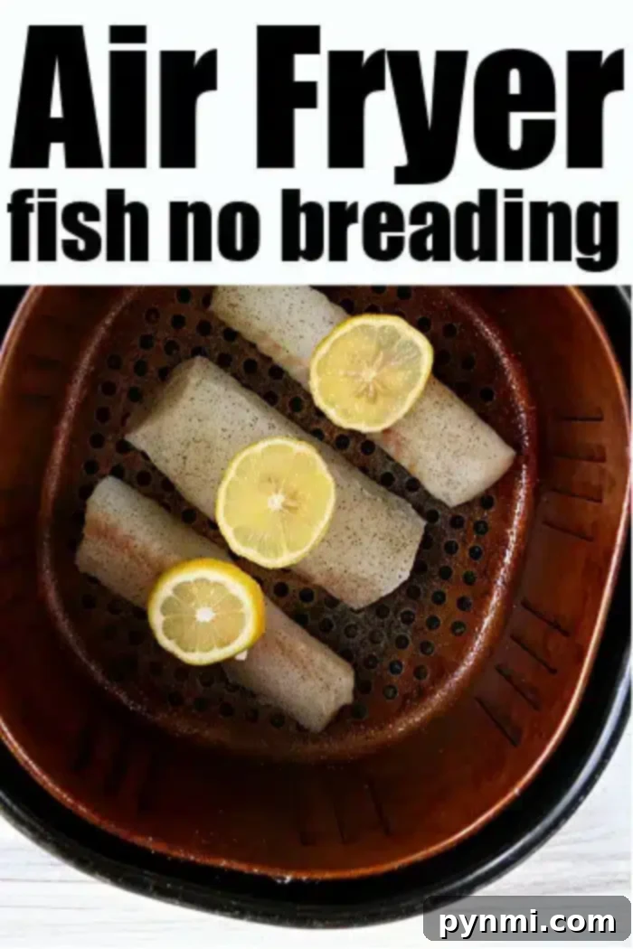 A close-up of three pieces of fish seasoned with black pepper and topped with lemon slices inside an air fryer basket. The text at the top reads, "Air Fryer Fish No Breading.