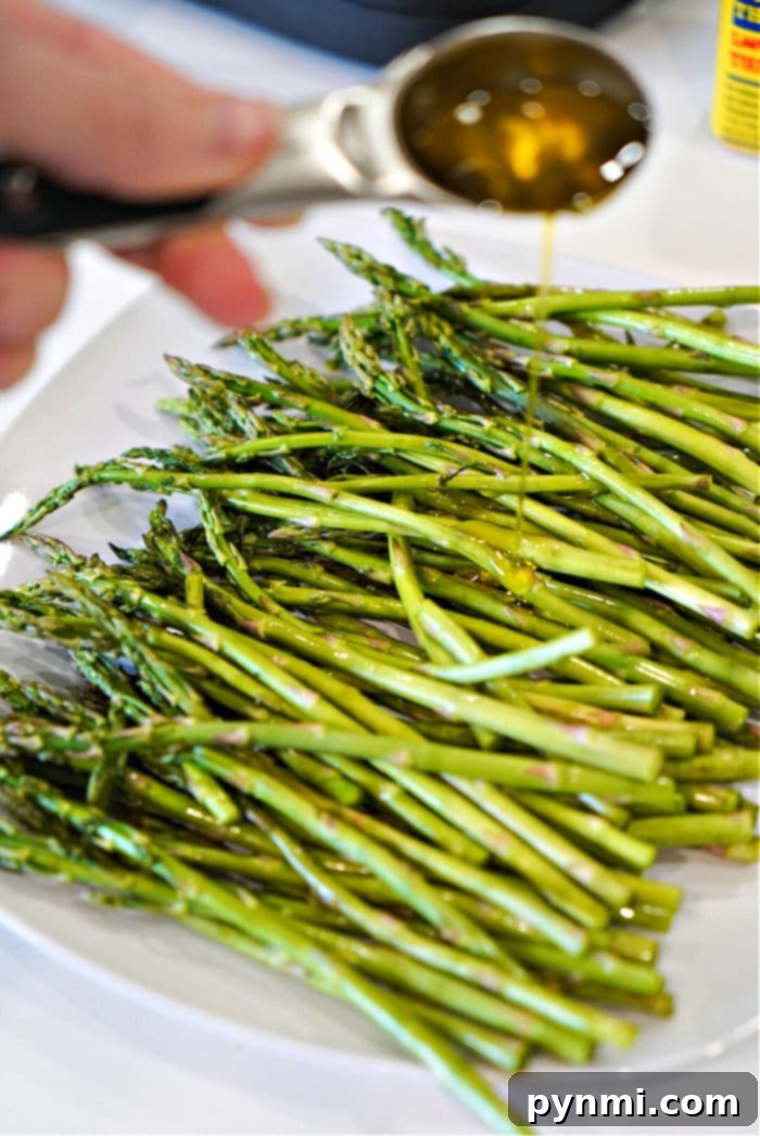 Ninja Foodi Air Fryer Asparagus: Quick & Crispy 6 A serving of air fryer asparagus recipe, tender and perfectly seasoned, on a white plate.