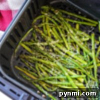 Asparagus in the air fryer topped with grated cheese, a perfect healthy side.
