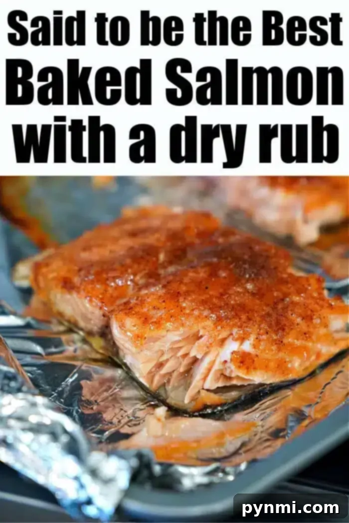 A close-up of the best baked salmon fillet, seasoned with a rich dry rub, presented on a foil-lined baking sheet. This highlights the perfect cooking and delicious appearance.