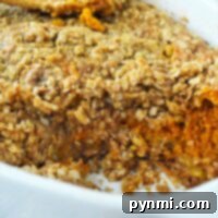 Baked sweet pumpkin crisp casserole with oat crumble topping in a white dish, reminiscent of a pumpkin crisp without cake mix.