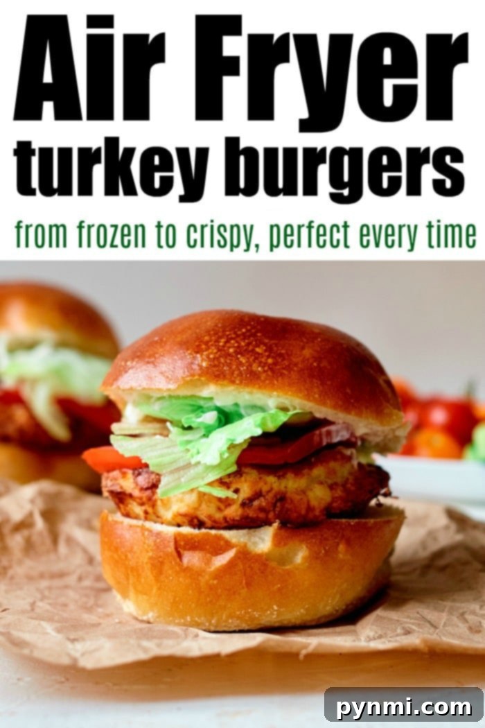A delicious air-fried frozen turkey burger on a bun with fresh lettuce and tomato, with another burger and the air fryer visible in the background.