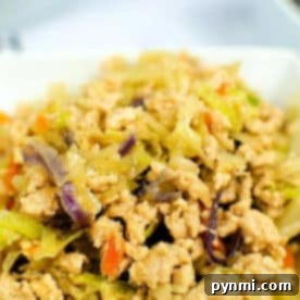 Instant Pot Egg Roll in a Bowl: Ground chicken stir-fry with shredded cabbage, carrots, and red cabbage, all served in a white bowl.