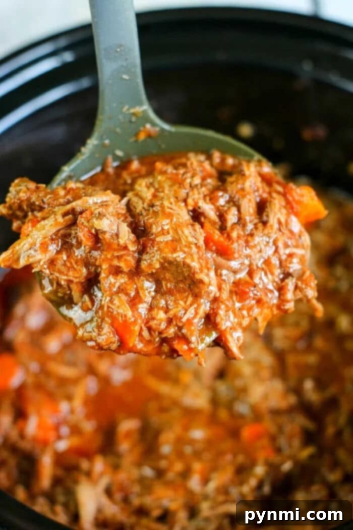 Effortless Slow Cooker Sunday Sauce 2 beef-ragu - Close-up of rich slow cooker shredded beef ragu in a pot, ready to be served over pasta.