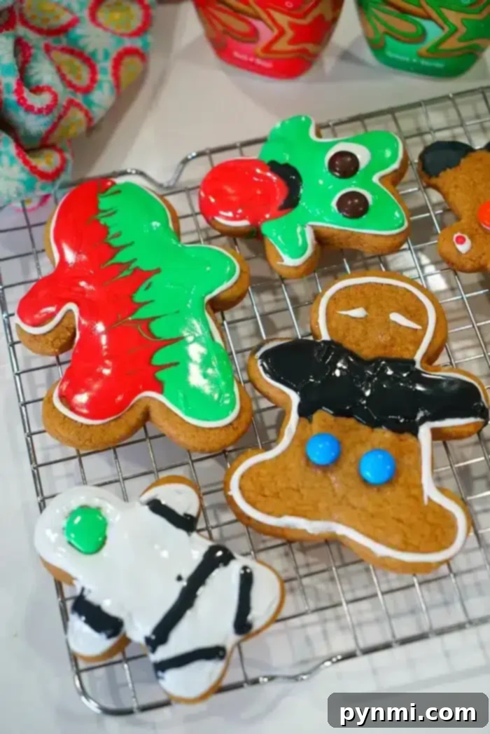 Colorful, decorated cake mix gingerbread cookies in various shapes rest on a cooling rack, adorned with festive icing and sprinkles.