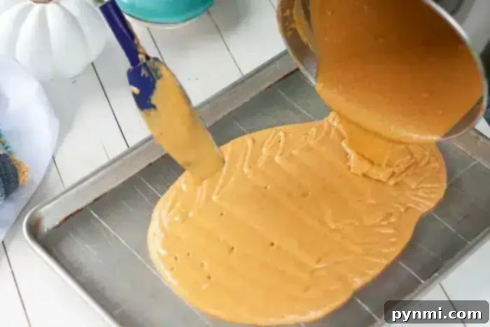 Effortless Half Sheet Cake Perfection 4 A thick, caramel-colored mixture is being poured from a pot onto a large metal baking sheet, perfect for creating a delightful 1/2 sheet cake.