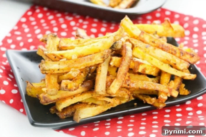 A plate of golden homemade fries with a side of dipping sauce.