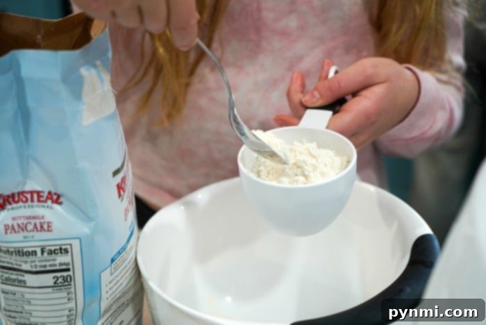Pancake batter being mixed in a bowl, illustrating the correct consistency for fluffy pancakes with some lumps.