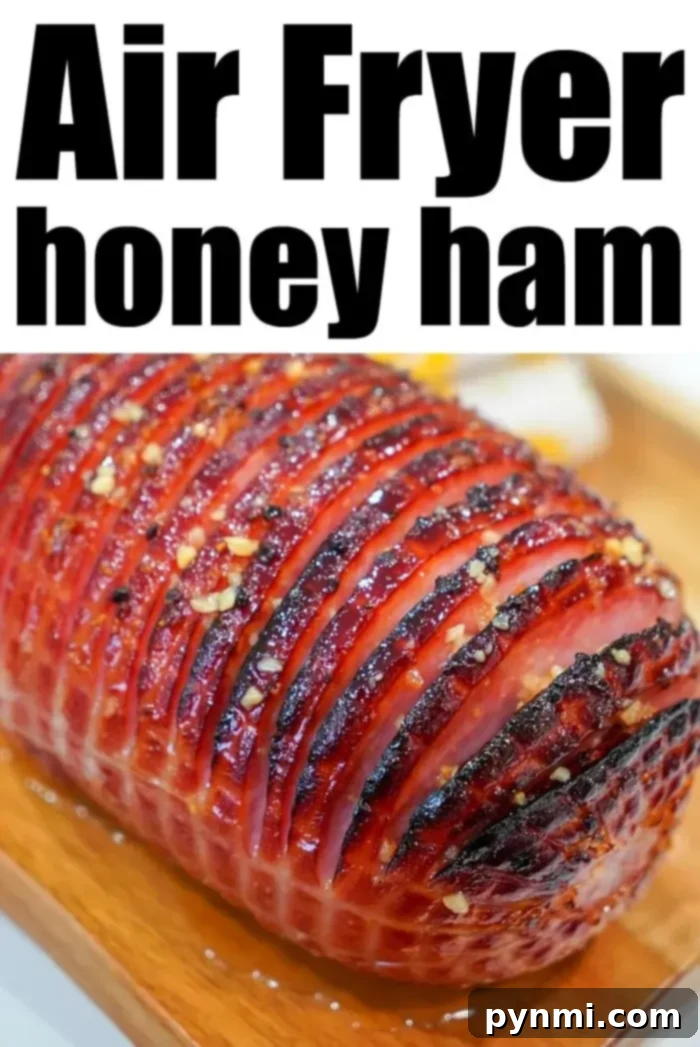 A close-up of a succulent honey-glazed air fryer ham with a perfect crosshatch pattern and caramelized crust, ready to be carved.