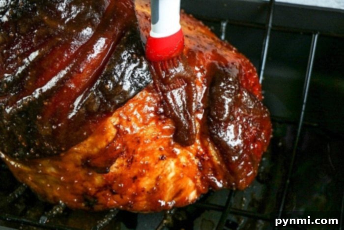 Decadent Bourbon Glazed Ham 5 ham with a thick, golden glaze being cooked