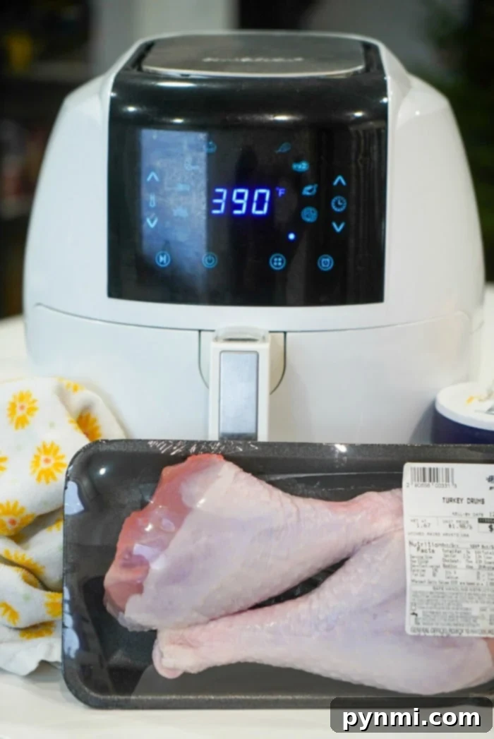 Two generously seasoned turkey legs cooking in an air fryer basket