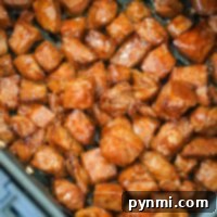 Juicy air fryer steak bites sizzle effortlessly in the basket, their seasoned cubes turning golden brown to perfection.