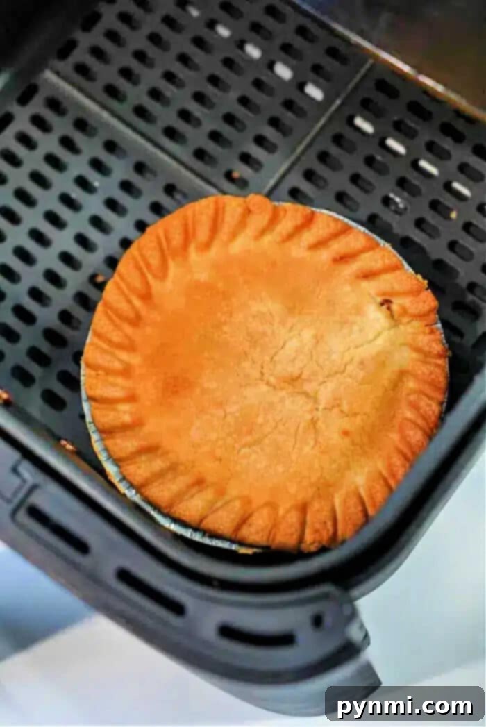 Crispy Air Fryer Frozen Pot Pie 9 A golden-brown frozen pot pie in air fryer sits perfectly crisp in the basket, ready to be served.