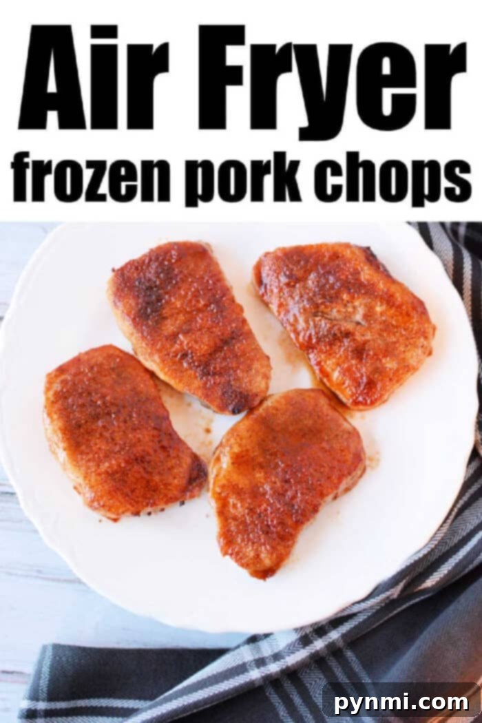 Perfectly cooked frozen pork chops in an air fryer basket, garnished with fresh herbs, ready to serve.