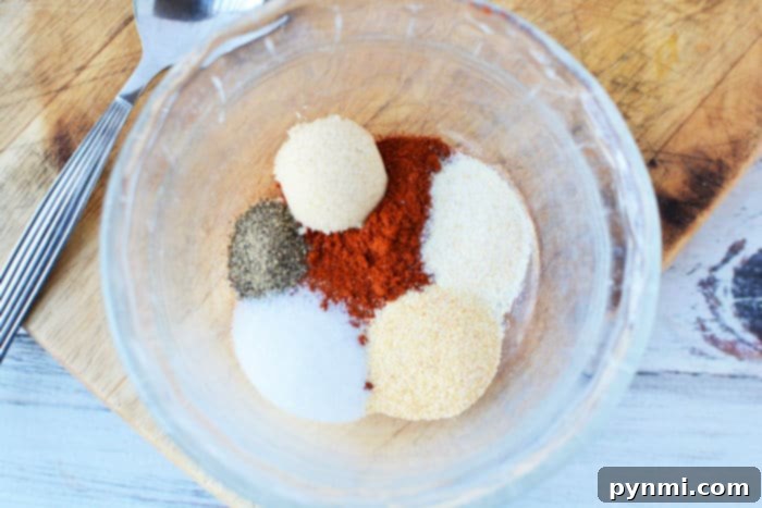 Close-up of frozen pork chops liberally seasoned with a homemade dry rub, showcasing the rich colors of the spices.