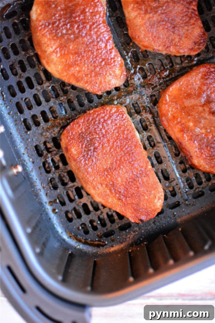A plate featuring two perfectly cooked air fryer frozen pork chops, artfully sliced to reveal their juicy interior, ready for a delicious meal.