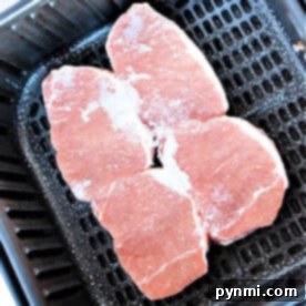 Frozen pork chops cooked to perfection in the air fryer, ready to be served.
